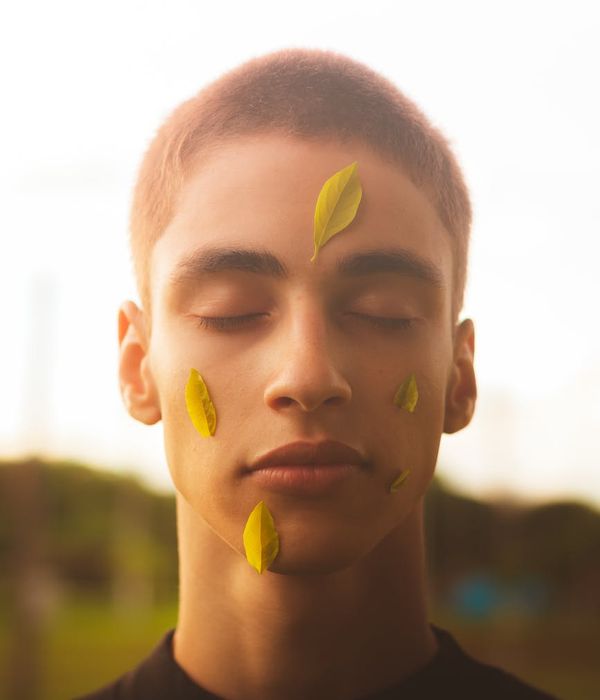 A serene person meditating with eyes closed in a calm, minimalist environment with soft lighting.